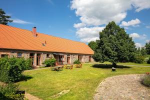 a building with an orange roof and a picnic table at Ferienwohnungen Hof Luisenau in Temmen-Ringenwalde