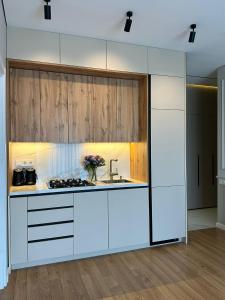 an open kitchen with white cabinets and a sink at Home Side Apartment in Batumi