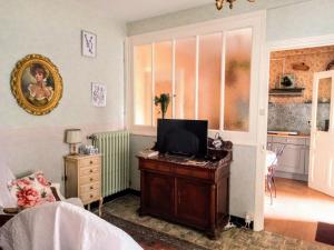 a living room with a television on a wooden table at Rosalie Cottage in Beaurepaire