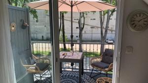 a patio with a table and chairs and an umbrella at La Riviera à 50m de la plage in Bénodet