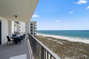 a balcony with a table and chairs and the beach at Phoenix 6 Unit 1213 in Orange Beach