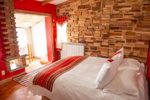 Un dormitorio con una cama con una pared de ladrillos. en Flamencos Altiplano Eco Hotel, en Ramaditas