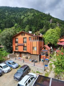 a large house with cars parked in a parking lot at Trend Suite Hotel in Uzungöl