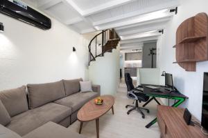 a living room with a couch and a desk at Sunlit & Sunny Rose Villas in Agios Nikolaos