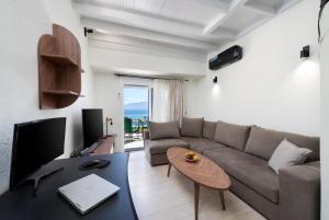 a living room with a couch and a table at Sunlit & Sunny Rose Villas in Agios Nikolaos
