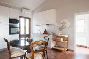 a kitchen with a table and chairs in a room at Macchie Basse Guest House - Agriturismo in Pescia Fiorentina