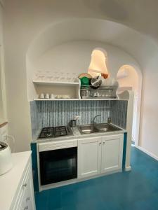 a small kitchen with a stove and a sink at Limoni in Praiano