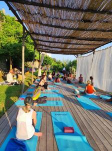 a group of people doing yoga on a wooden deck at Limoni in Praiano