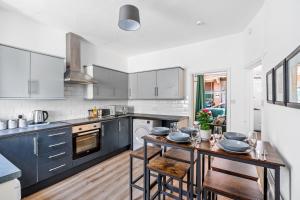 a kitchen with a table with dishes on it at The Old Laundry - FREE Parking - Town Centre in Worthing