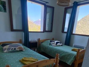two beds in a room with two windows at Auberge de Thiéry in Thiéry