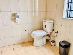 a bathroom with a toilet in a tiled room at Budget Cozy home in Kampala in Kampala