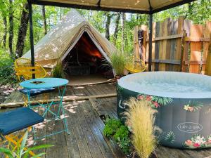 a tent with a hot tub and a table and chairs at CYBÈLE in Bernac