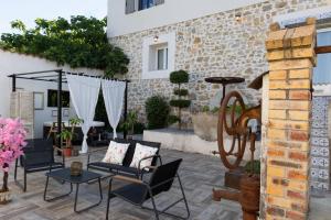 a patio with chairs and tables and a building at Moulin du désir in Montauroux