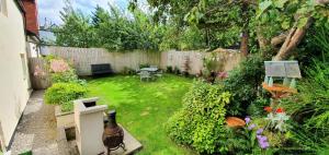 a small garden with a fence and a table and chairs at Vale View Cottages -The Coach House, Great location in Prestatyn! in Prestatyn