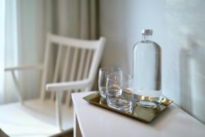 two glasses and a bottle on a tray on a table at Arkösunds Hotell in Arkösund