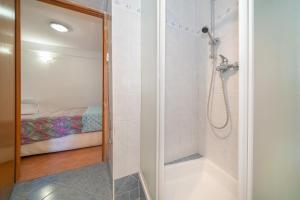 a bathroom with a shower and a bed at Jasmina-Room in Jurandvor