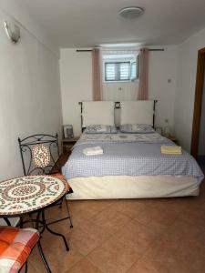 a bedroom with a large bed and a table at Jasmina-Room in Jurandvor