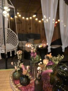 una sala de estar con una mesa con jarrones y flores en Le Nid Cosy Bordeaux, en Burdeos