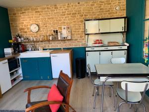 a kitchen with a table and chairs in a room at Gite du point du jour - Prêt de velos in Luc-sur-Mer +6 photos