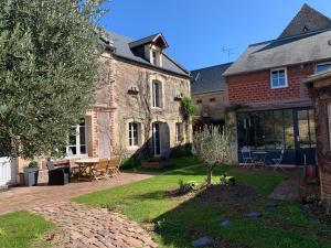 a large brick house with a yard with a tree at Gite du point du jour - Prêt de velos in Luc-sur-Mer