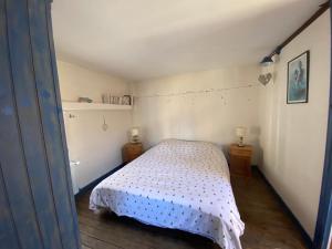 a small bedroom with a bed with a white bedspread at Gite du point du jour - Prêt de velos in Luc-sur-Mer