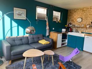 a living room with a couch and a kitchen at Gite du point du jour - Prêt de velos in Luc-sur-Mer