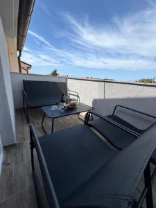 a balcony with a table and a bottle of wine at Apartmani M&L in Medulin