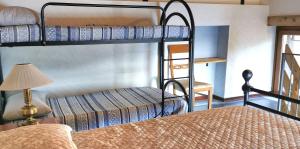 a bedroom with two bunk beds and a lamp at Baita Michele con Terrazzo e bellissima Vista Lago x 4 Persone in Aurano