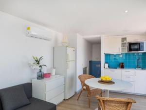 a living room with a table and a kitchen at Apartment Mestral Atic by Interhome in Tossa de Mar +15 photos
