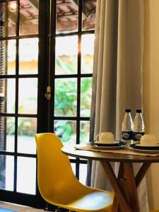a table and two chairs and a table and a window at Canto do Una- hospedagem in Barra do Una