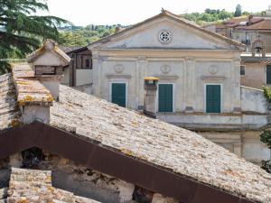 an old building with green windows on top of a roof at Casa Silvia in Bracciano