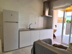 a white kitchen with a sink and a refrigerator at Estudio SoleArte en Lajares in Lajares