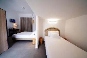 two beds in a hotel room with two beds at Ducas Rooms and Suite in Lascari