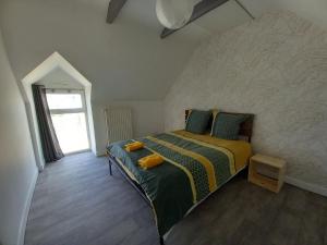 a bedroom with a bed with green and yellow sheets at Odet, maison avec grande terrasse in Rosporden