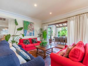 salon z czerwonymi kanapami i stołem w obiekcie Villa La Font by Interhome w mieście Mancor del Valle