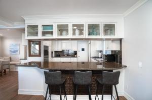 a kitchen with white cabinets and a bar with stools at 1011 N Bayfront A & B in Newport Beach +38 photos