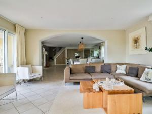 un salon avec un canapé et une table dans l'établissement Holiday Home La pinède by Interhome, à Thèzan-lès-Béziers