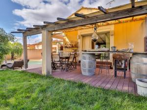 une terrasse en bois avec une cuisine et un bar avec un grill dans l'établissement Holiday Home La pinède by Interhome, à Thèzan-lès-Béziers