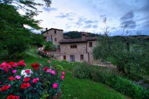 une maison sur une colline avec des fleurs devant elle dans l'établissement Agriturismo Ardene, à Montepulciano