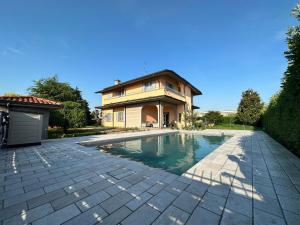 ein Haus mit einem Swimmingpool vor dem Haus in der Unterkunft Villa 2 in Cassano dʼAdda