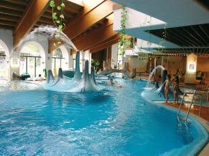 a group of people riding a water slide in a pool at Appartements DIANA in Bad Kleinkirchheim