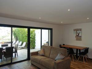 a living room with a couch and a table at Apartment Les Jardins d'Ève- F3 by Interhome in Favone