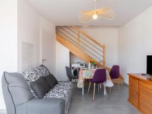 ein Wohnzimmer mit einer Couch und einem Tisch mit Stühlen in der Unterkunft Apartment SC G01 by Interhome in Mimizan