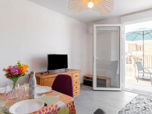 ein Wohnzimmer mit einem Esstisch und einem TV in der Unterkunft Apartment SC G01 by Interhome in Mimizan + 26 Fotos