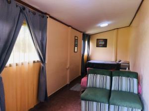 a small room with two chairs and a window at Hotel Cocodrilo Sierpe in Sierpe