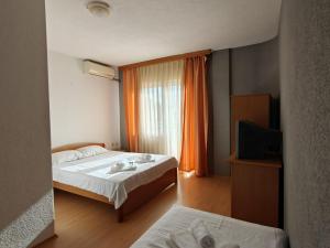a hotel room with two beds and a window at Hotel Ariston in Struga