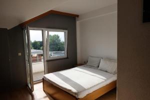 a bedroom with a bed and a large window at Hotel Ariston in Struga