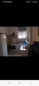 a small kitchen with a stove and a refrigerator at Casa inflorita garsoniere etaj in Eforie Nord