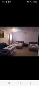 a room with two beds and a table in it at Casa inflorita garsoniere etaj in Eforie Nord