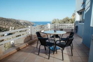 a table and chairs on a balcony with the ocean at MountSea Villa in Agios Nikolaos